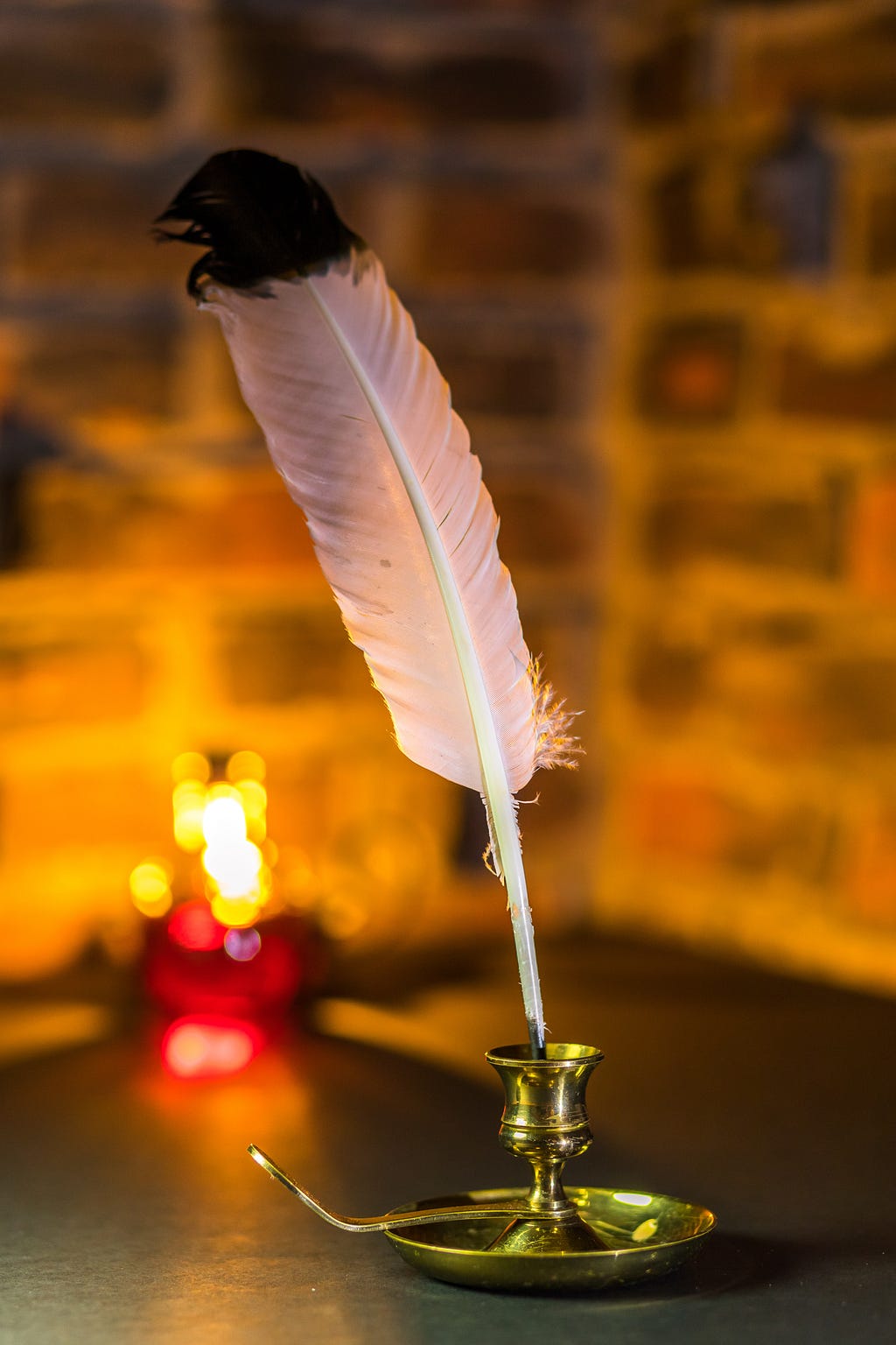 A quill pen in front of a warmly lit but out of focus background
