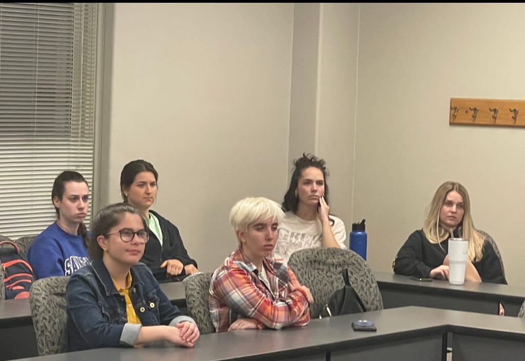 Six student watching a zoom presentation in a classroom.