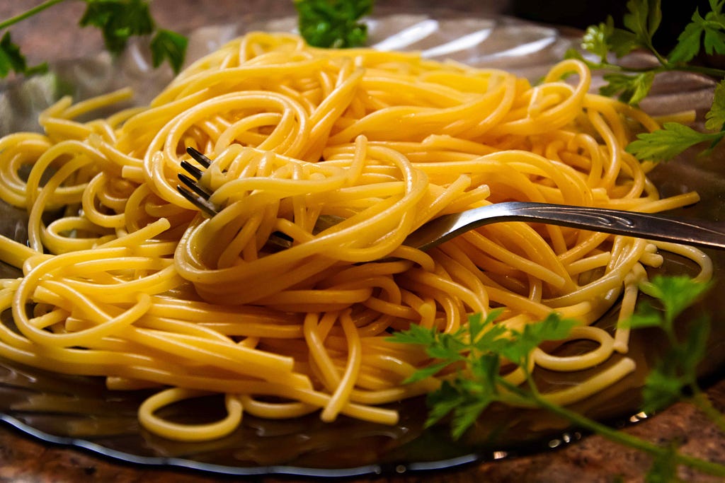 Close up of yellow spaghetti noodles garnished with parsley