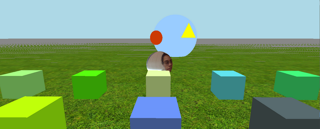 Virtual field with a grass floor and 4 cubes. a face s in the middle of the field.