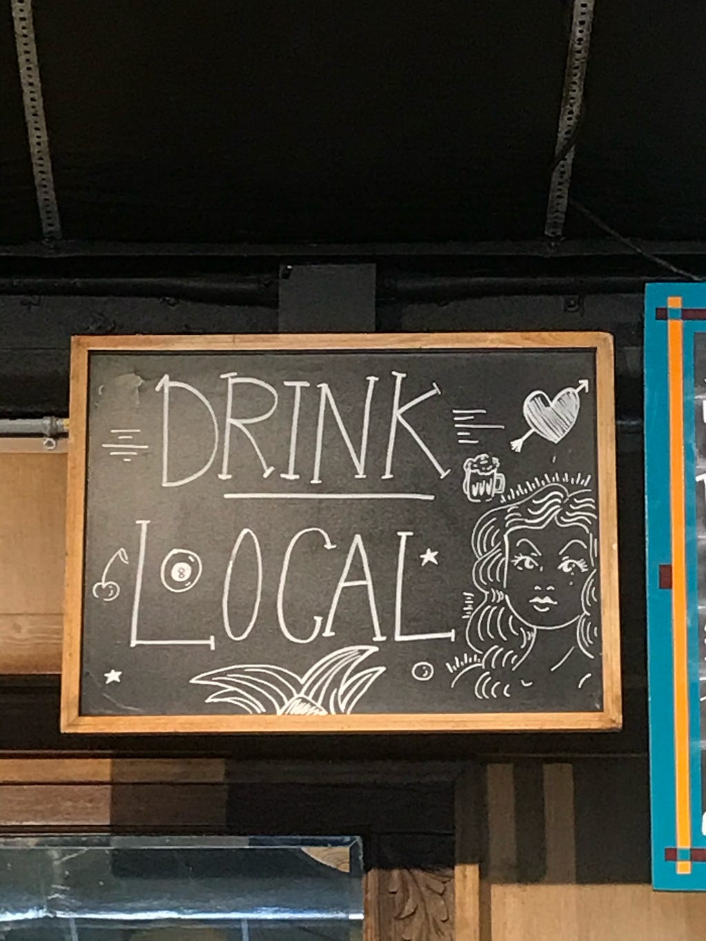 Sign inside Cherrywood Coffeehouse that reads “Drink local”