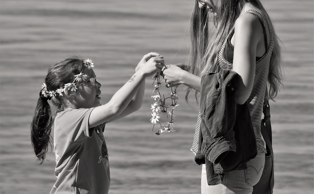 Mum and child making flower chains.