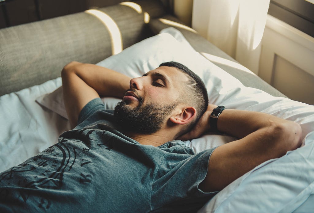 A man sleeping with hands behind his back