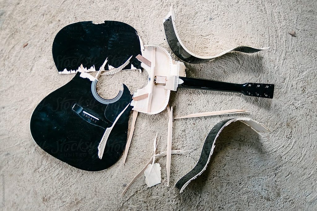 A smashed guitar on the ground