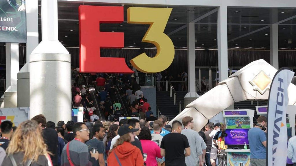 A giant E3 sign is hanging above a crowd of people at a gaming convention