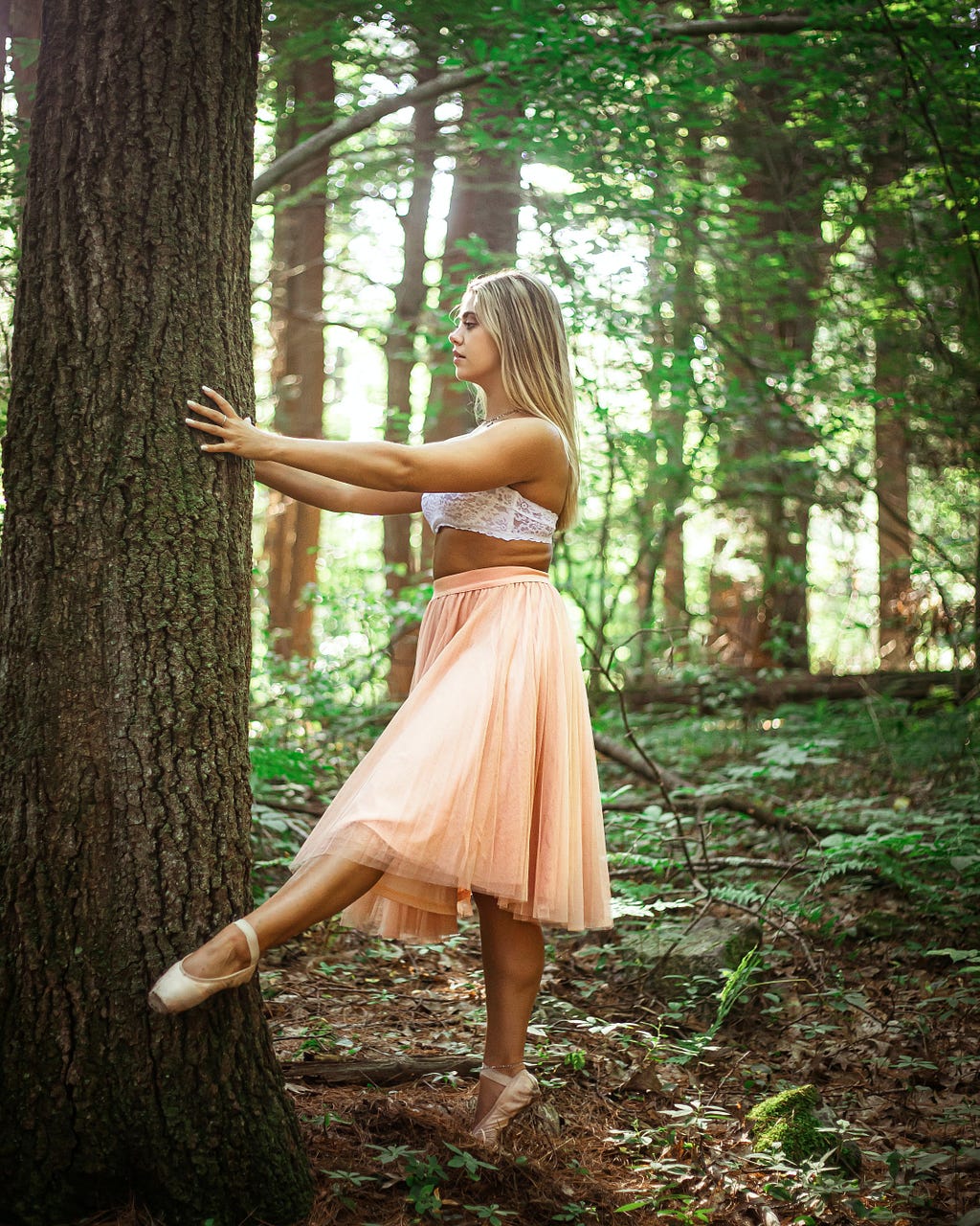 Bigger sized dancer, on pointe, holding onto a tree