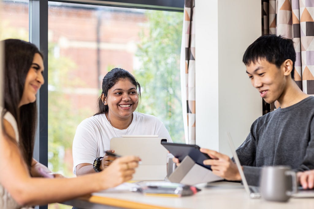 Three students working together in their kitchen