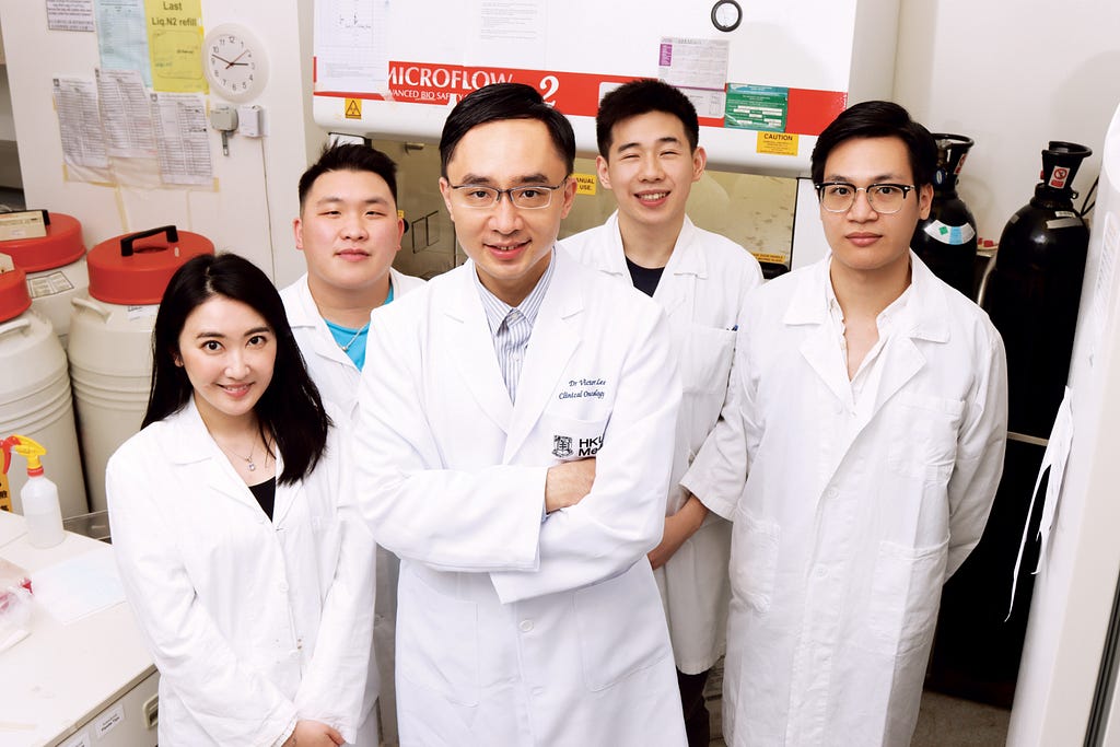 A group of 5 Hong Kong medical researchers with Dr Victor Lee Ho-fun in the middle, smiles at the camera in a wet lab