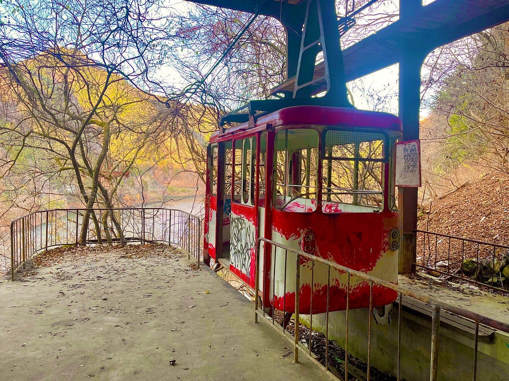 Abandoned cable car near the top of a mountain overlooking a lake