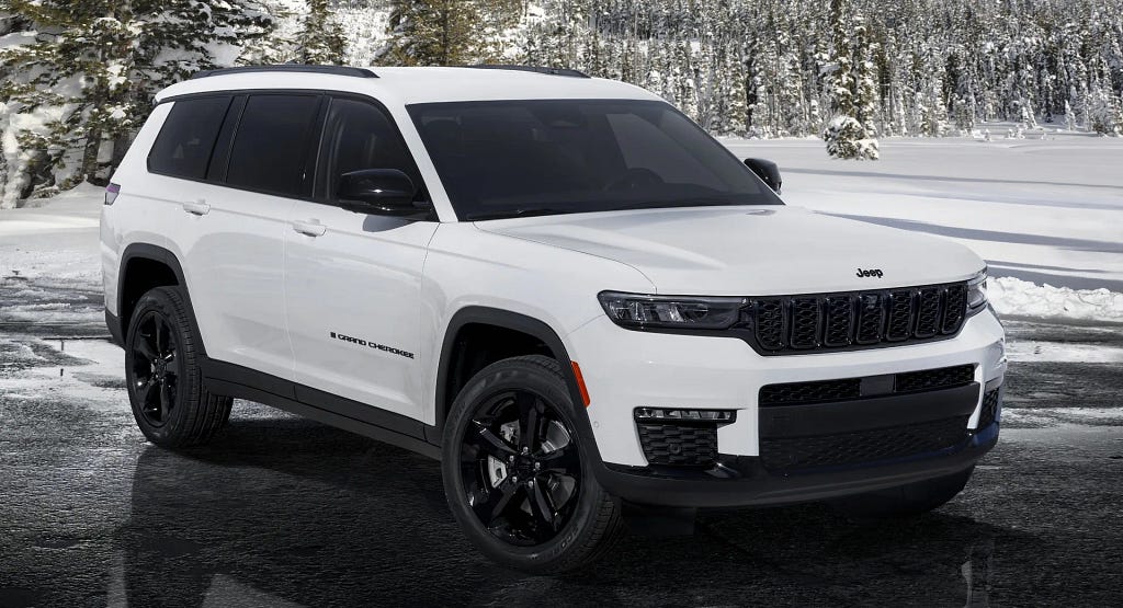 A white Jeep Grand Cherokee in a snowy location.