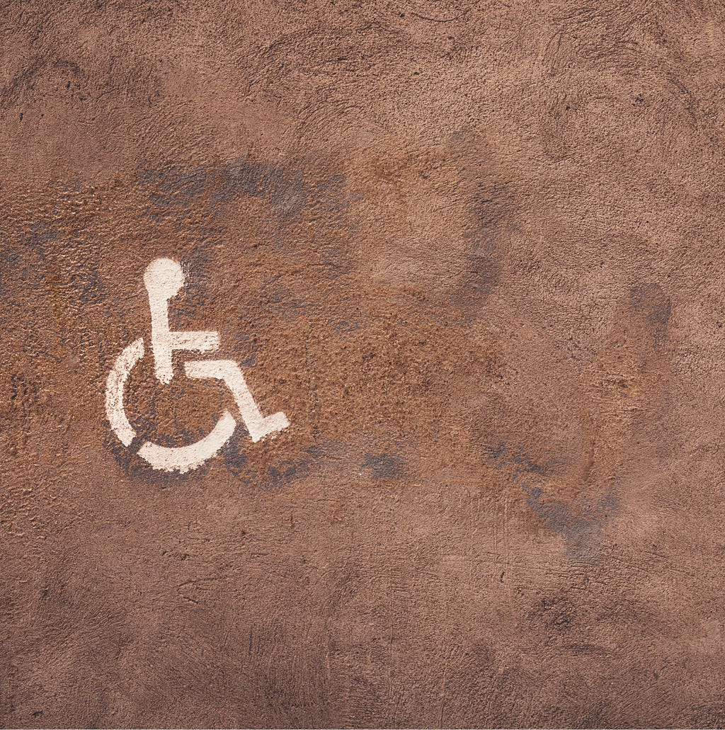 Símbolo de acessibilidade pintado em fundo de cimento.