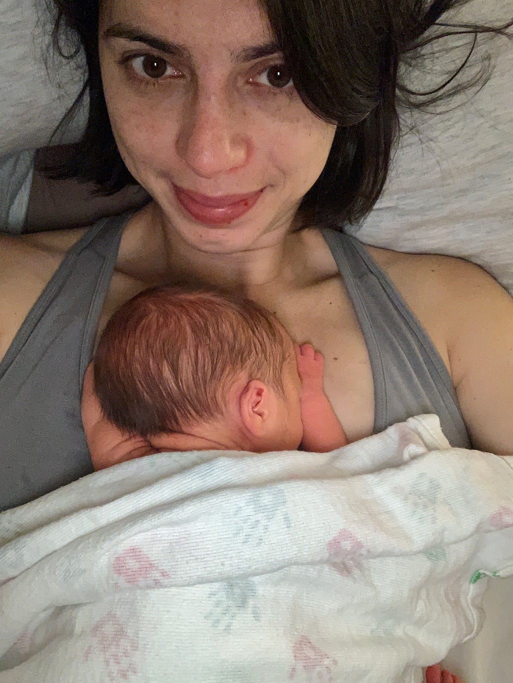 A close-up shot of a mom holding her newborn on her chest