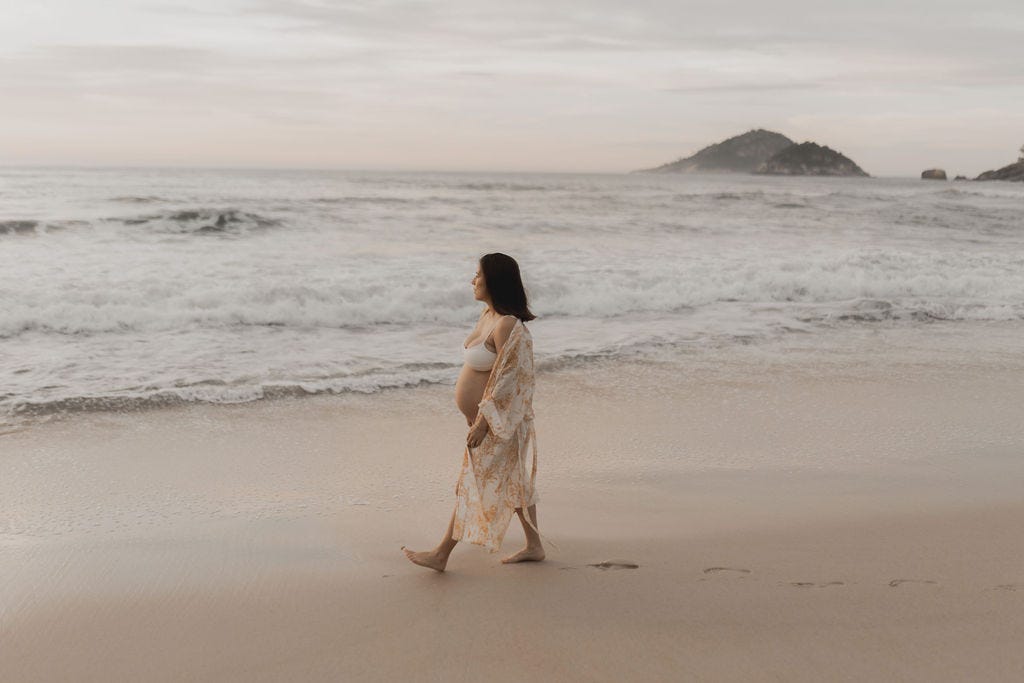 Pregnant woman walking on the seashore