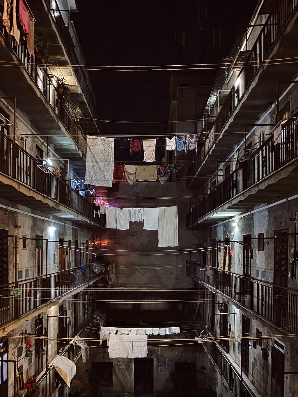 An urban apartment building with clothes hanging out to dry in the night