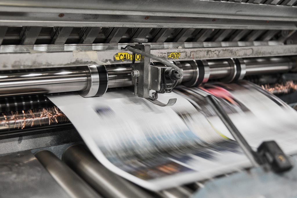 Closeup of newspapers being printed in printing press