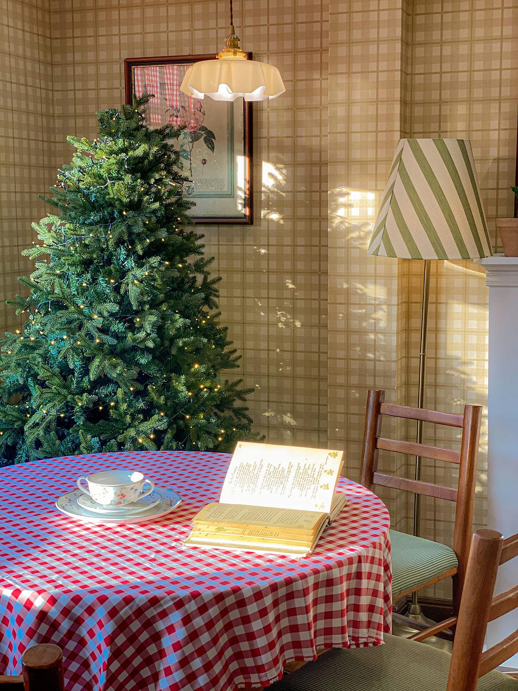 Stock photo of Christmas tree and table with open book and tea