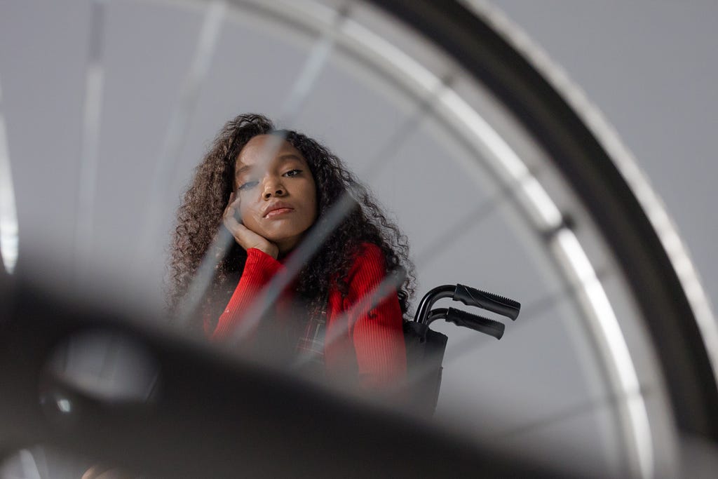 Woman in Red Long Sleeves Sitting on a Wheelchair