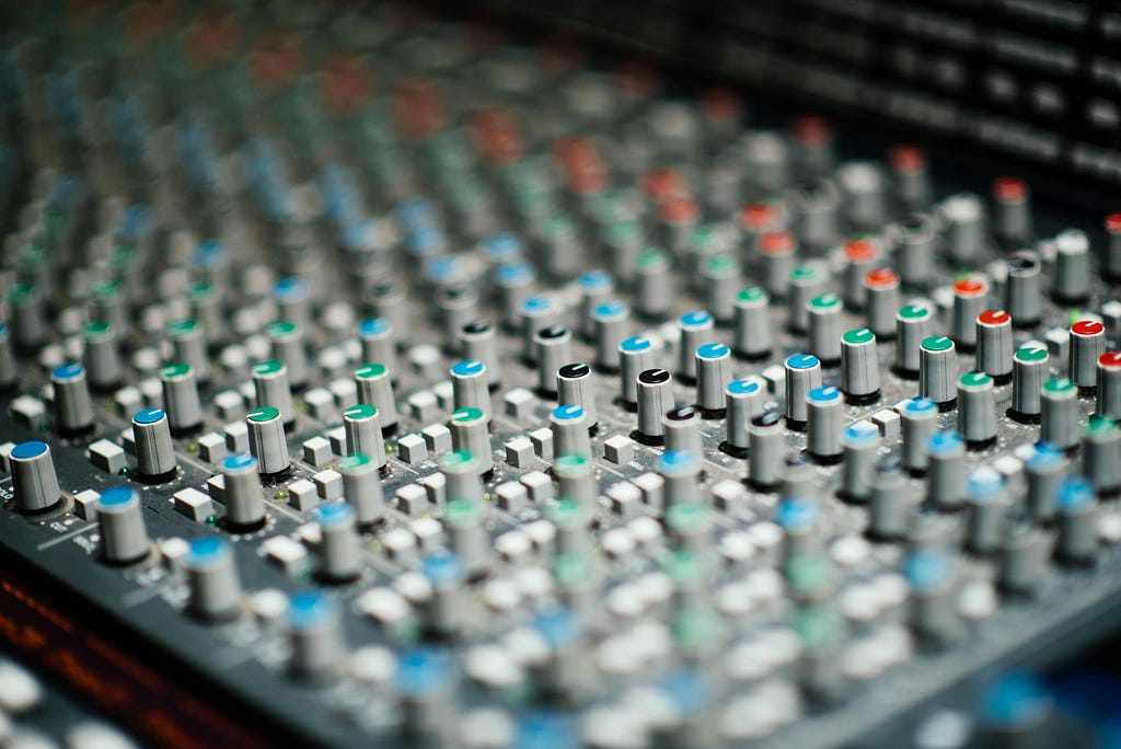 A mixing board with dozens of unlabeled dials