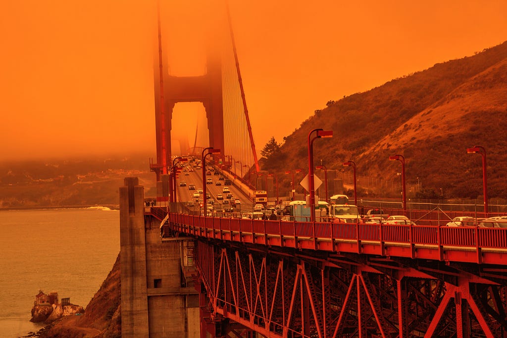 Cars crossing the Golden Gate Bridge in San Francisco under a smoky orange sky caused by California wildfires. Photo by bennymarty/Getty Images