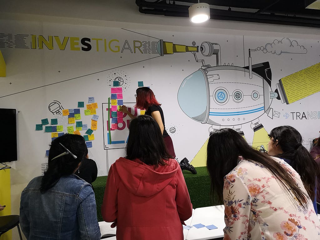 Foto de mujeres reunidas trabajando en co-creación utilizando post-its