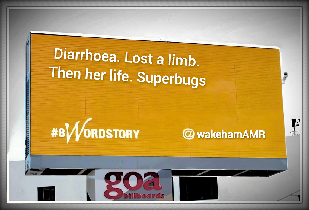 Billboard with orange screen and in white is written “Diarrhoea. Lost a limb. Then her life. Superbugs.” Underneath that on bottom left is written #8Wordstory and on the bottom right @wakehamAMR