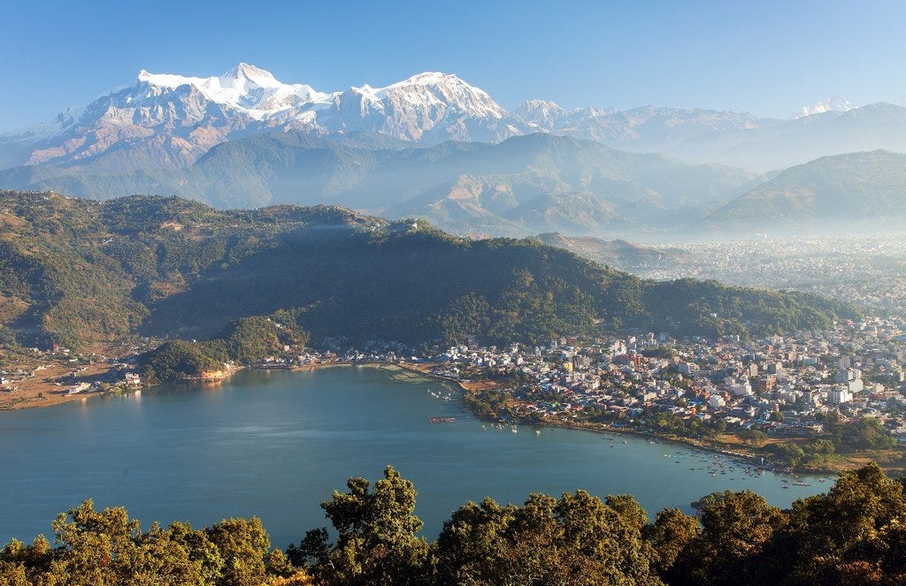 A Photo of a Annapurna mountain, Pokhara city and Phewa Lake taken from a high place.