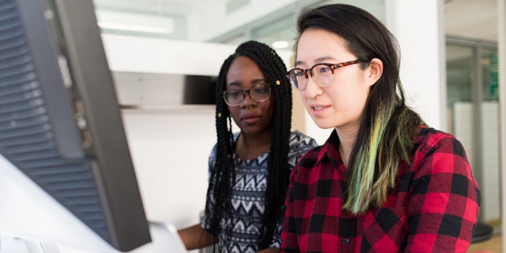 Two BIPOC women sitting at laptop.