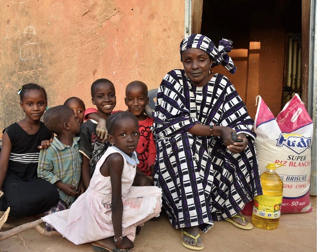 Ada et ses petits-enfants devant sa maison, après avoir acheté des vivres pour nourrir sa famille nombreuse. Photo : PAM/Mahamadou ABDOURHAMANE.