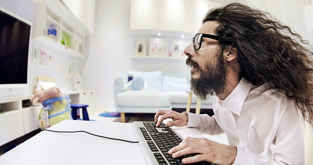 Man working at computer with hair blown back.