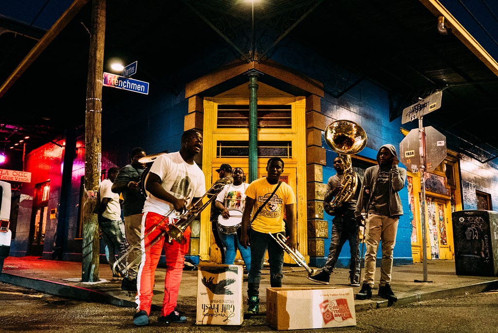 Image shows musicians getting ready to play on a street corner.