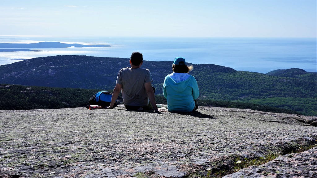 D and I sitting on the peak of Cadillac Mountain in Acadia National Park enjoyin breakfast