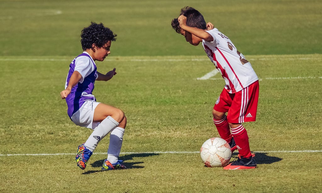 two six year olds play one on one soccer