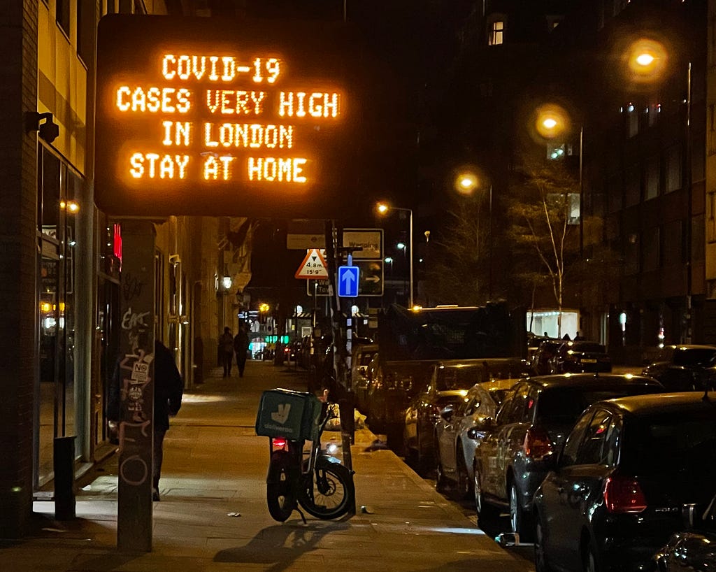 A digital traffic sign reads “Covid-19 cases very high in London, Stay at home”