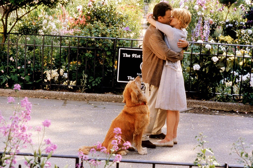 Tom Hanks and Meg Ryan as Joe and Kathleen kissing at the end of You’ve Got Mail in New York with Joe’s dog Brinkley.