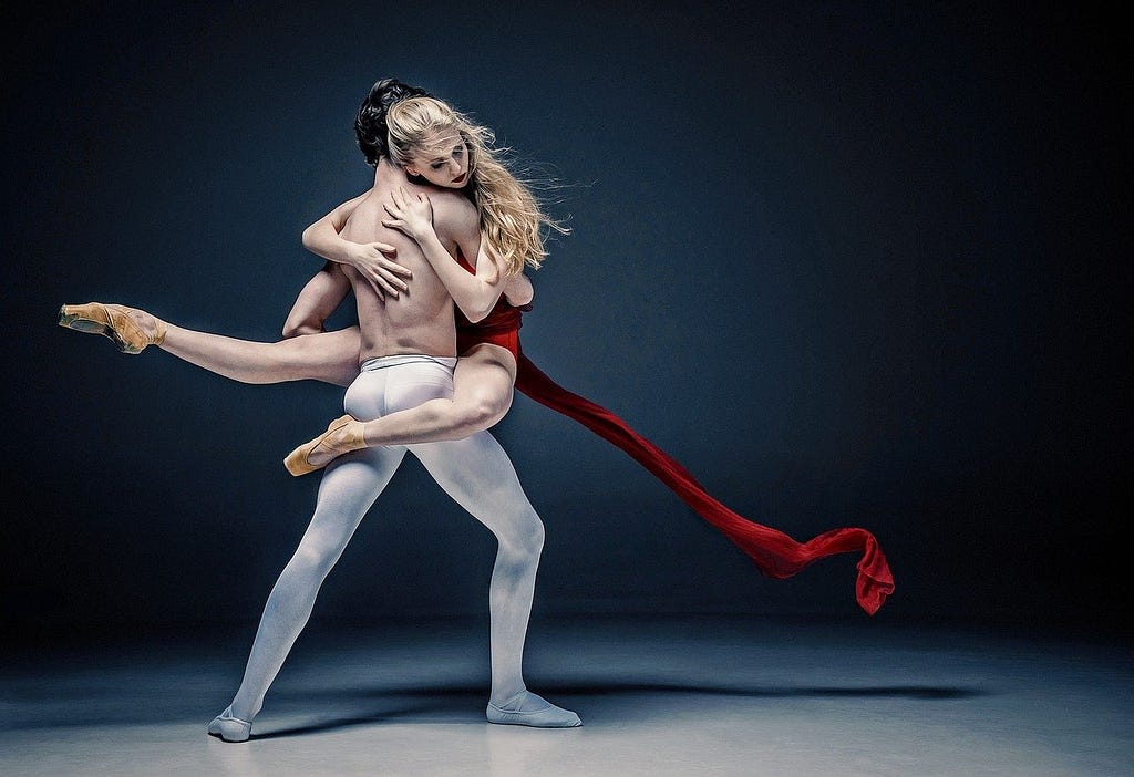 A picture of a woman being carried by a man in a dance pose.