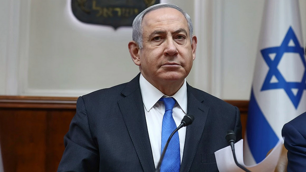 Benjamin Netanyahu on a podium with microphones pointed at him.