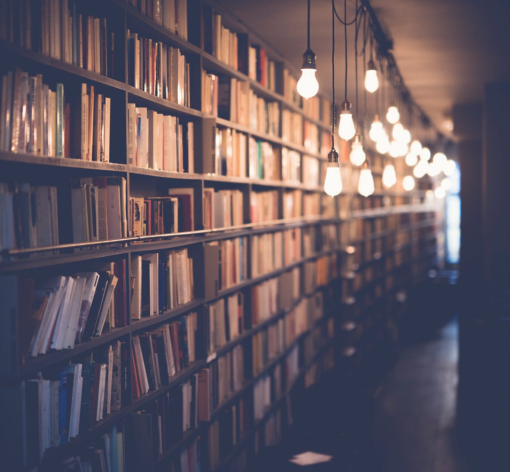 Picture of a well lit library with lot of books.