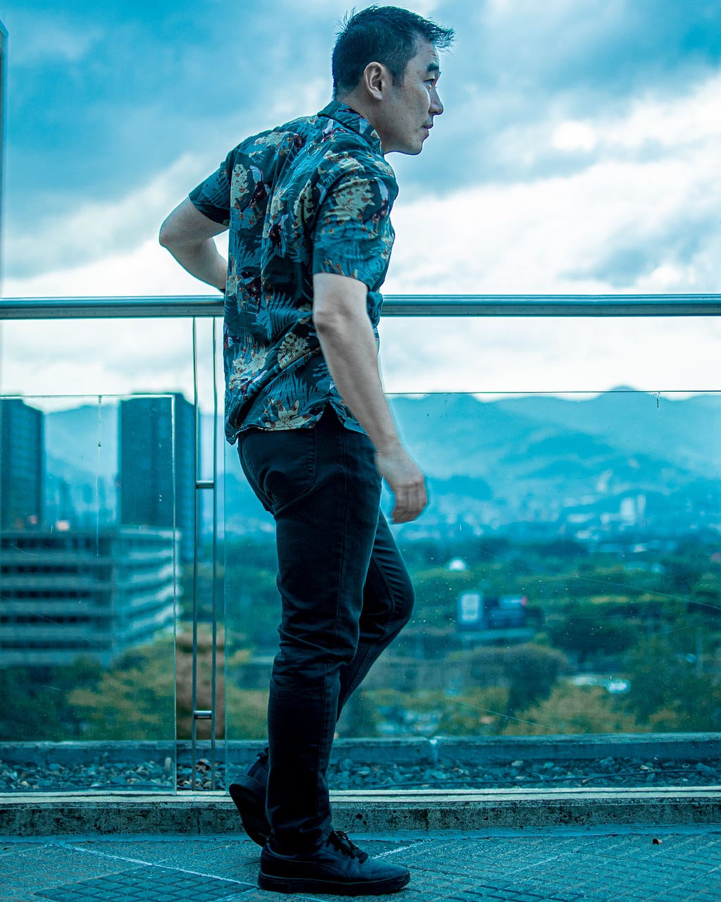 Overseeing the city of Medellin at the Medellin Modern Art Museum — Wearing floral shirt and emerald pants with black Puma tennis shoes. Men style and fashion in Latin America — Status detox in Medellin — post