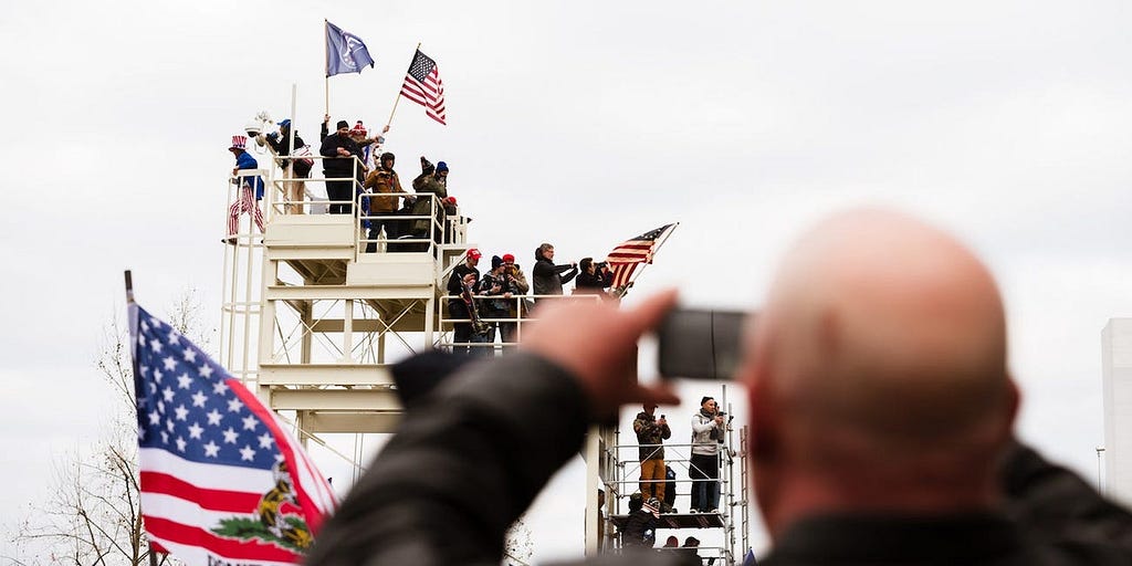 A pro-Trump protester takes a photo of other protesters on the grounds of the Capitol Building on January 6, 2021.