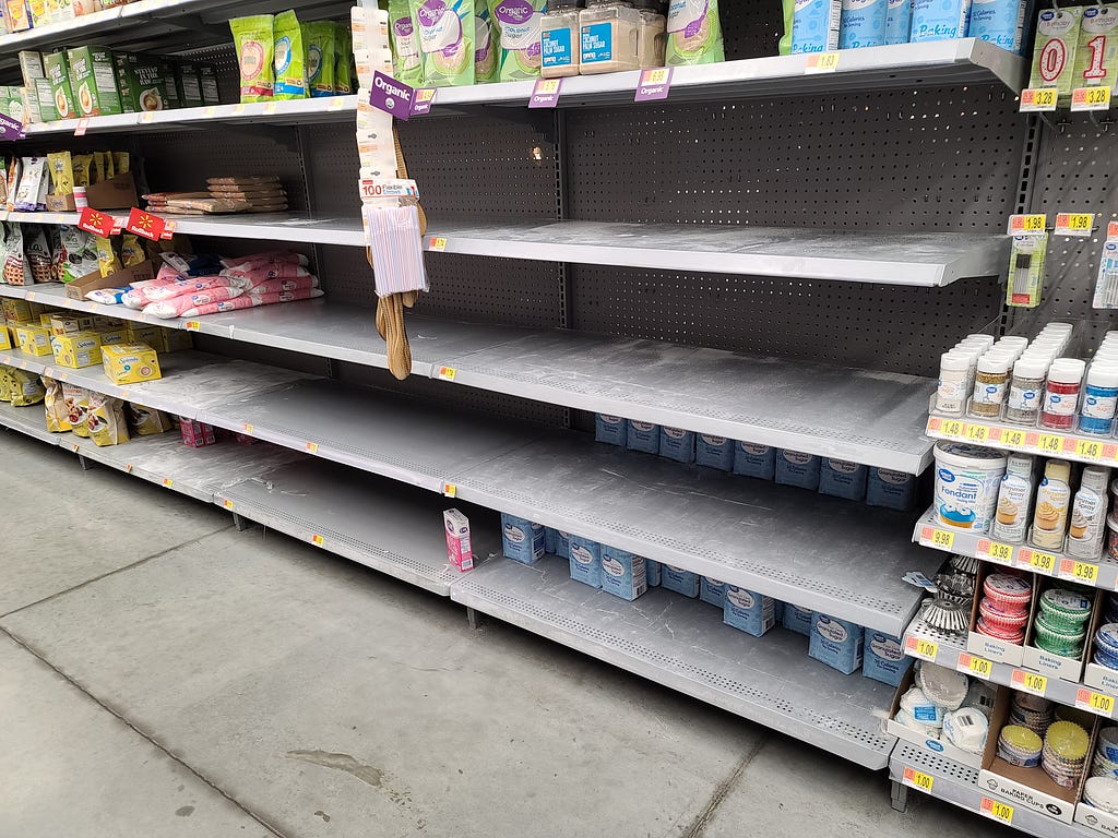 A photograph of bare shelves at a grocery store during the COVID-19 pandemic.