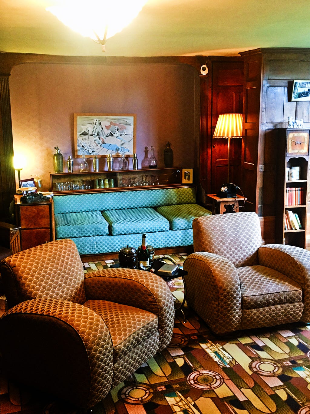 1930s deco living room with lounge suite, lamps and book shelves