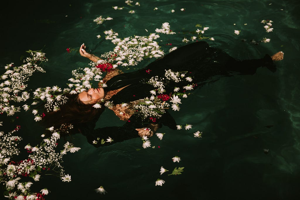 A serene woman floating in a pond.