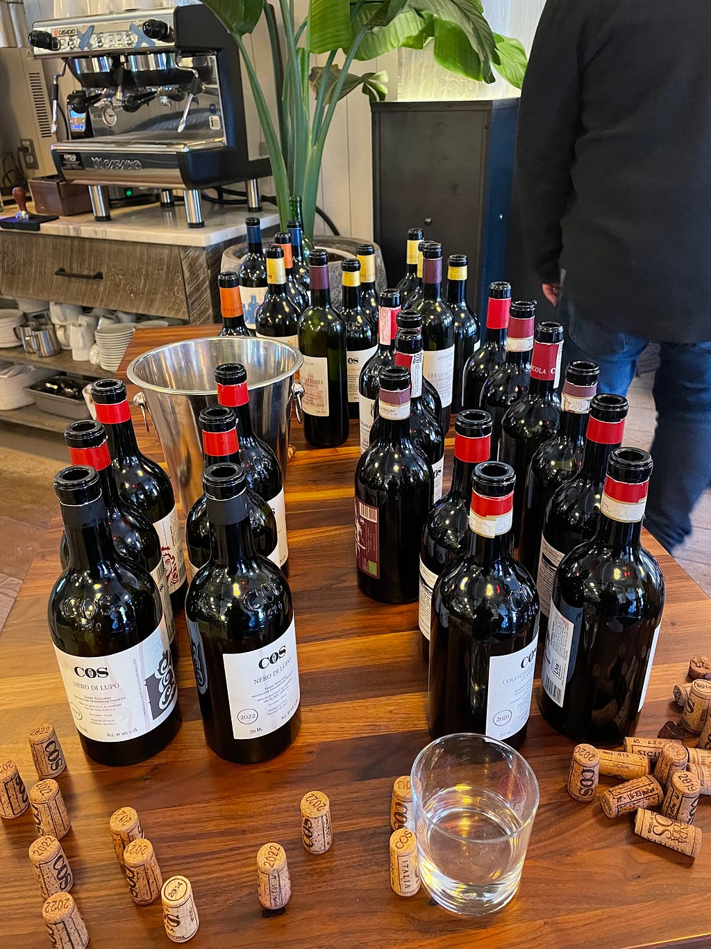 Several bottles of wine cluttered on a wooden table