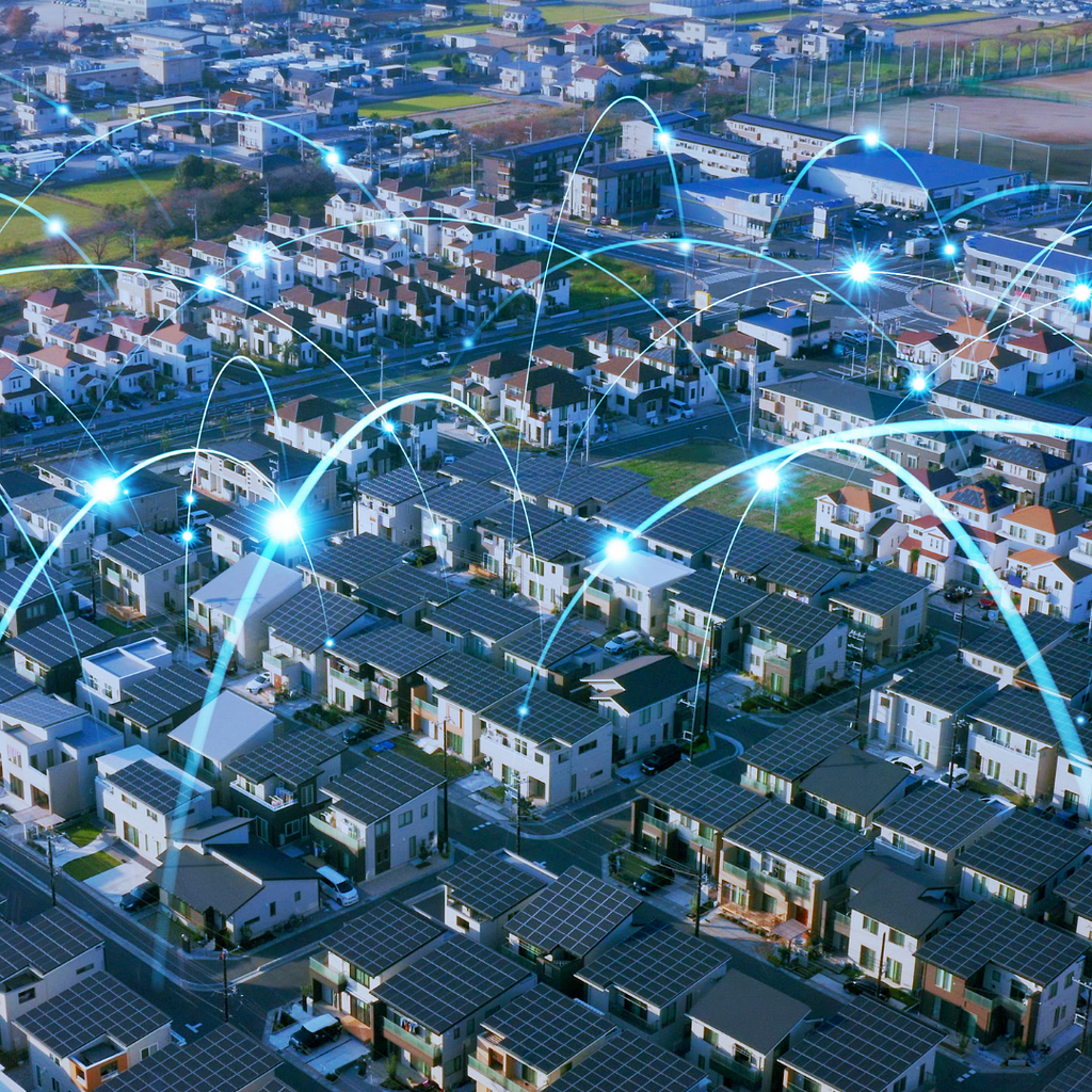 An aerial view of a modern suburban neighborhood with solar panels on rooftops and digital connections highlighted by blue lines, representing a smart city with sustainable energy solutions and interconnected technologies.