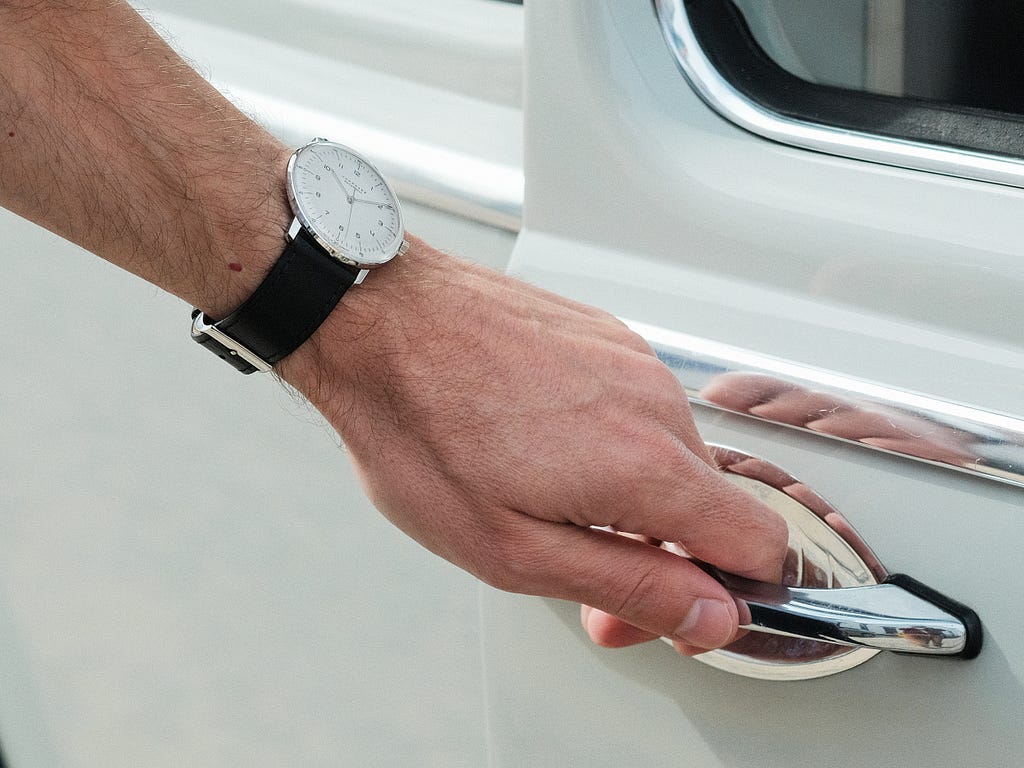 Junghans Max Bill on the wrist while opening the Volkswagen Beetle door