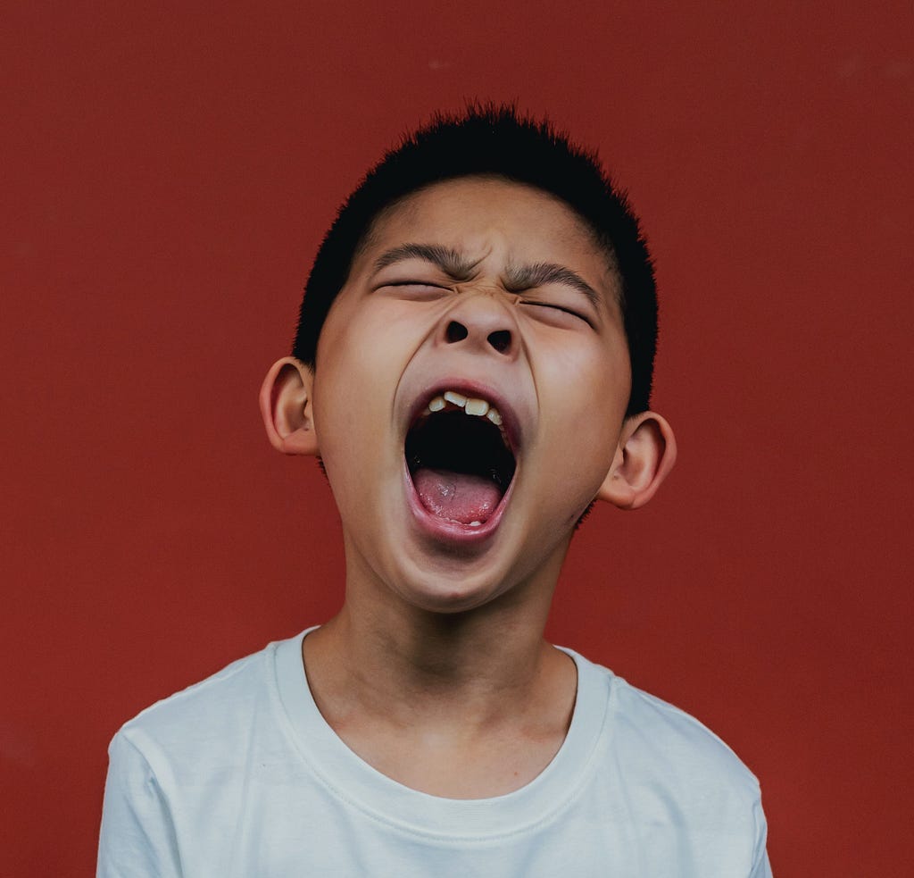 A young boy with his mouth wide open screaming, on a red background, Nyk, Medium