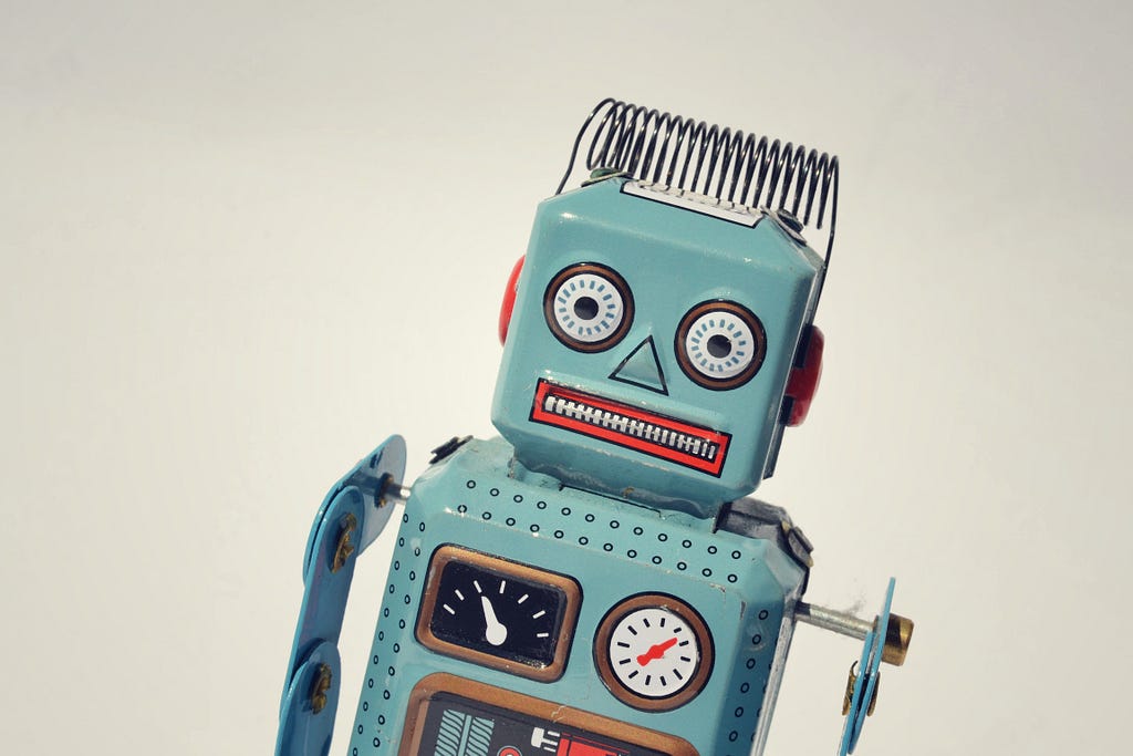 A tin robot toy looks at the viewer with a comical expression on its face