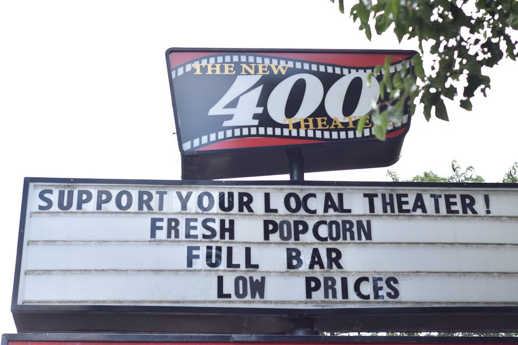 The New 400 Theater puts signs written “support your local theater” on its marquee board to call for residents of Rogers Park, Chicago before it sells to a new buyer. (Andrew Fang)