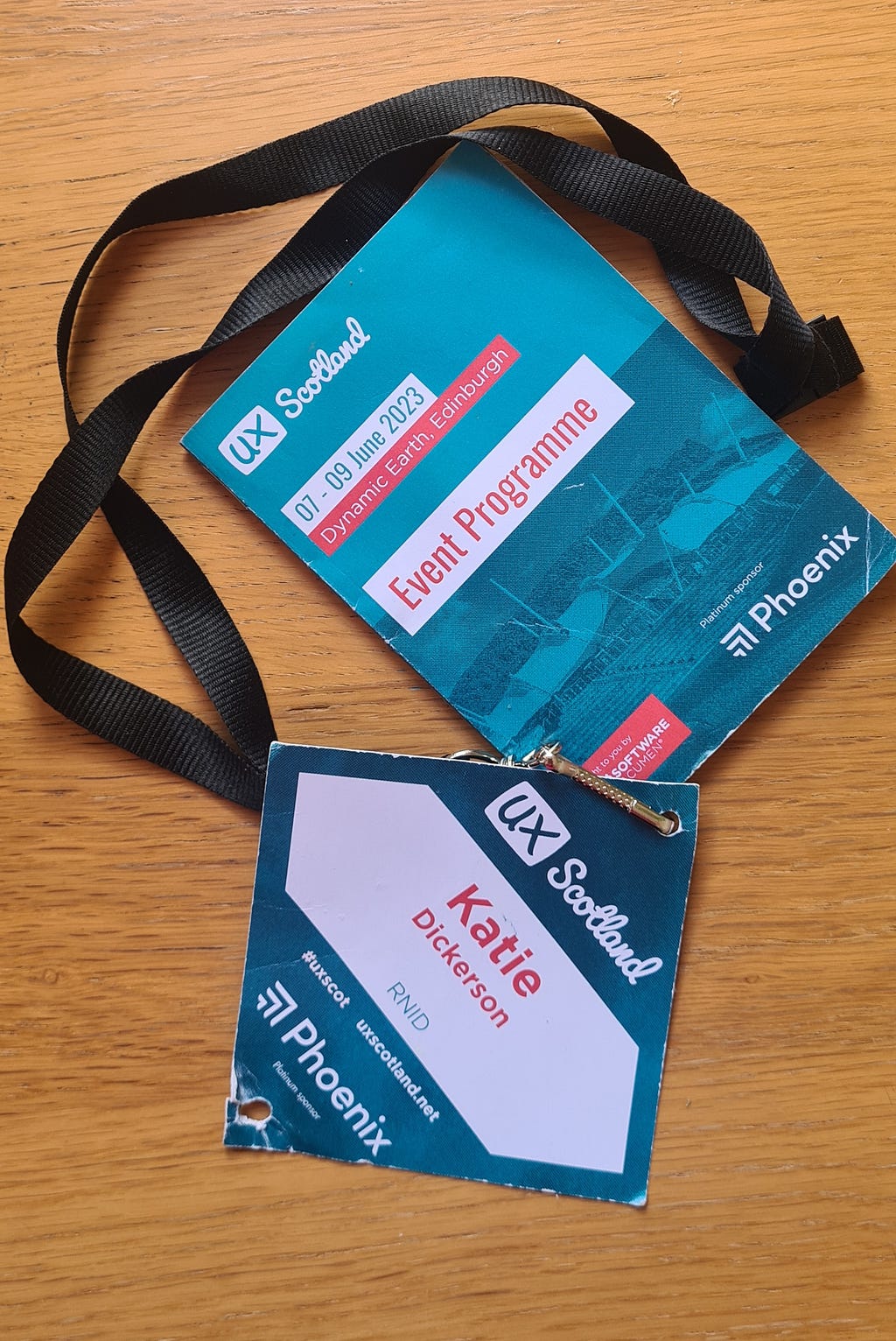 A lanyard with a UX Scotland event programme and name tag that says ‘Katie Dickerson, RNID’.