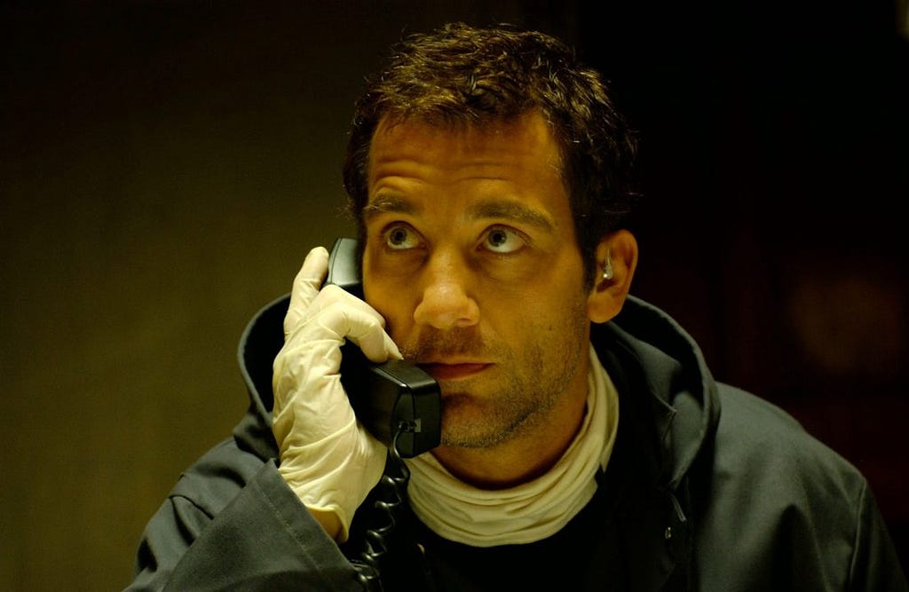 Clive Owen holds a phone to his ear in Inside Man